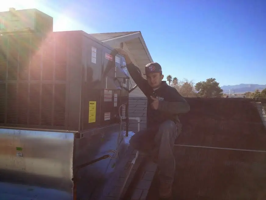 HVAC technician performing AC Tune-Up on a rooftop unit in Youngtown